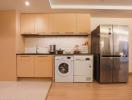 Modern kitchen with wood cabinets, stainless steel appliances, and integrated laundry machine