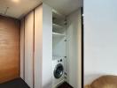 Modern utility area with built-in washing machine and ample storage space