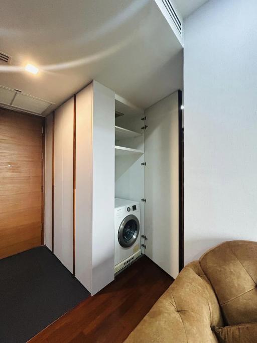 Modern utility area with built-in washing machine and ample storage space