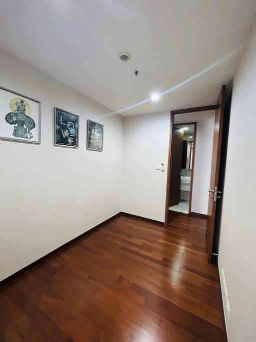Spacious and well-lit hallway leading to rooms with hardwood flooring