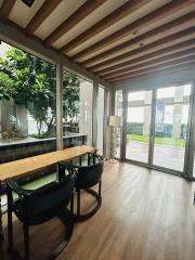 Elegant dining area with wooden flooring and large windows