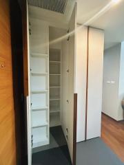 Compact storage closet with white shelves and wooden doors