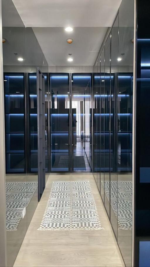 Elegant walk-in closet with mirrored doors and custom shelving