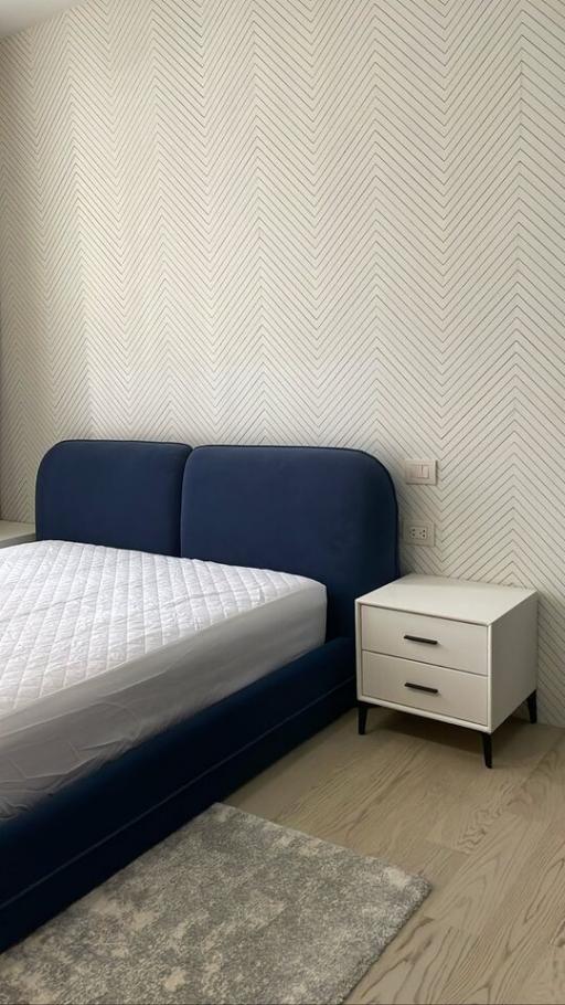 Modern Bedroom with Herringbone Pattern Wallpaper and Blue Bed