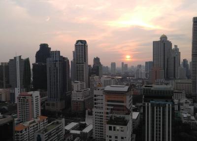 Sunset over a bustling cityscape with high-rise buildings