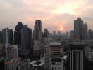 Sunset over a bustling cityscape with high-rise buildings