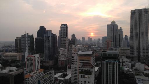 Sunset over a bustling cityscape with high-rise buildings