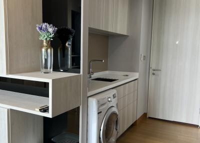 Compact modern kitchen with integrated appliances and wooden flooring