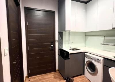 Modern kitchen with wood flooring, white cabinets, and built-in appliances