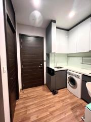 Modern kitchen with wood flooring, white cabinets, and built-in appliances