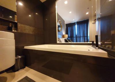 Modern bathroom with bathtub and bedroom view