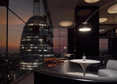 Modern living room with panoramic city view at sunset