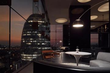 Modern living room with panoramic city view at sunset