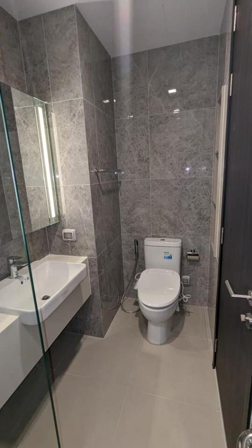 Modern bathroom with grey tiles and glass shower enclosure