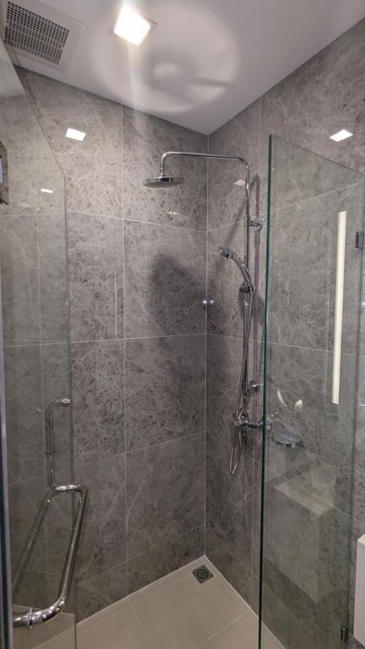 Modern bathroom with glass shower enclosure and grey tiles