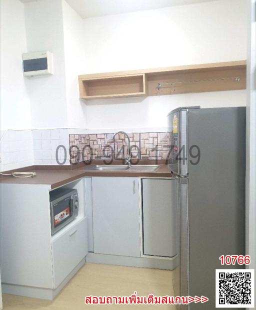 Modern compact kitchen with stainless steel refrigerator and built-in appliances