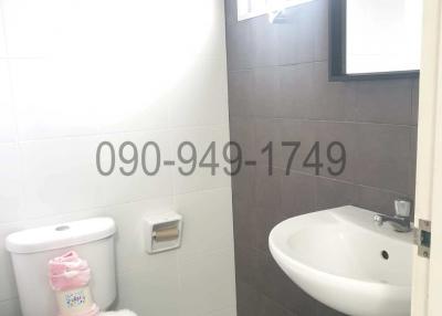 Compact white and grey tiled bathroom with natural light