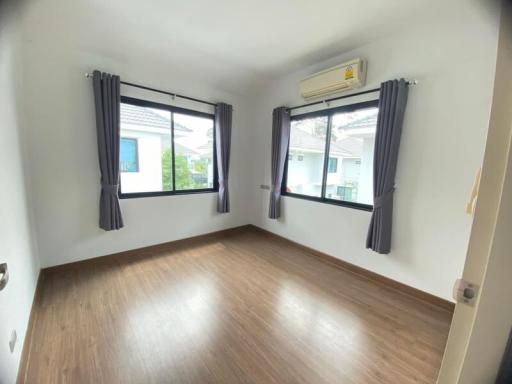 Empty bedroom with two windows and air conditioning unit