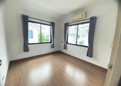 Empty bedroom with two windows and air conditioning unit