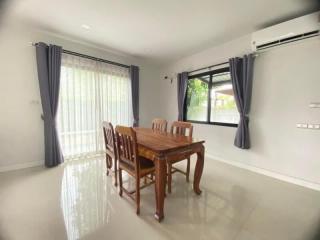 Spacious dining room with large window and elegant wooden table