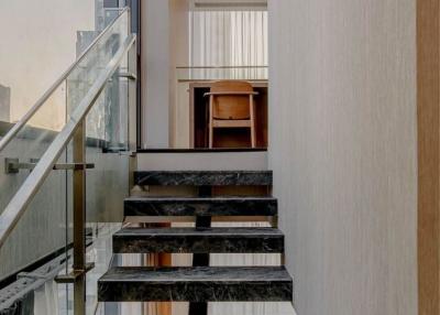 Modern staircase with glass railing and marble steps in a luxury home