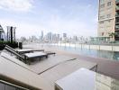 Modern rooftop swimming pool with city skyline view and lounge chairs