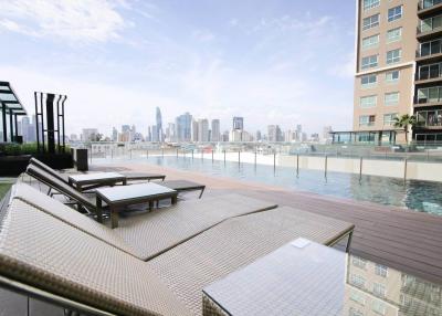 Modern rooftop swimming pool with city skyline view and lounge chairs