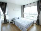 Spacious bedroom with large window and city view