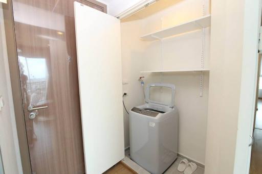 Compact laundry room with washing machine and built-in shelves