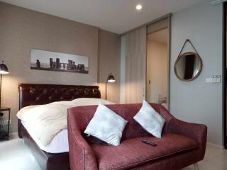 Modern bedroom with a comfortable red sofa and a queen-sized bed