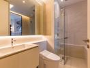 Modern bathroom with well-lit vanity, spacious shower area, and beige tiles