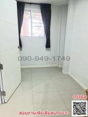 Empty bedroom with tiled floor and window with navy blue curtains