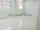 Bright empty room with glossy tiled floor and multiple windows