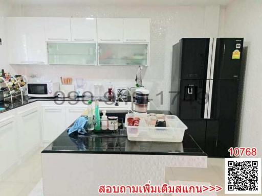 Modern kitchen with white cabinets and black refrigerator