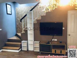 Cozy living room interior with staircase and mounted television