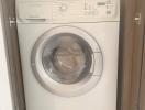 Modern white Electrolux washing machine in a compact laundry area within a home