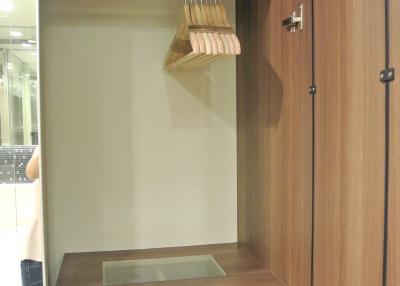 Modern bedroom closet with built-in wooden shelves and drawer