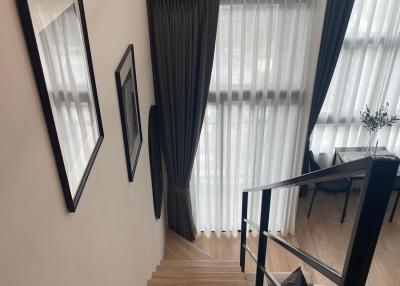 Elegant wooden staircase with white walls and framed pictures leading to the upper level of a home