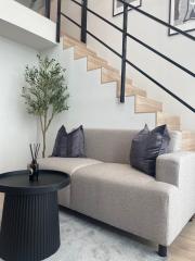 Modern living room with staircase and comfortable sofa
