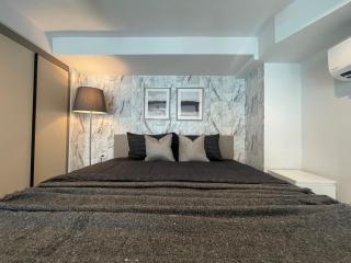 Modern bedroom with a large bed, stylish wall design, and air conditioning unit