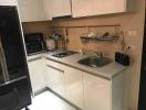 Compact modern kitchen with stainless steel sink and built-in appliances