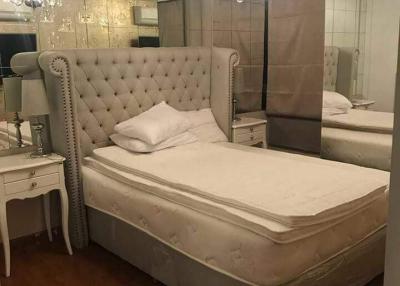 Elegant bedroom with large tufted headboard and mirrored wardrobe