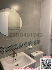 Modern bathroom interior with wall-mounted sink, toilet, and mirrored cabinet