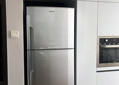 Modern kitchen with stainless steel refrigerator and built-in oven