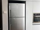 Modern kitchen with stainless steel refrigerator and built-in oven