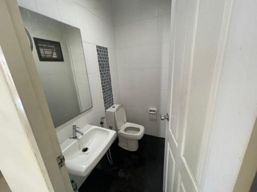 Compact bathroom with white tiles, modern fixtures, and black flooring