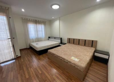 Spacious bedroom with two beds and ample natural light