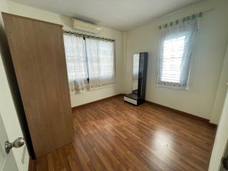 Spacious bedroom with wooden flooring and air-conditioning unit