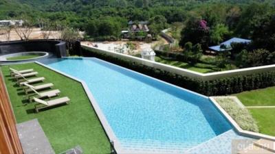 Luxurious outdoor swimming pool with sun loungers and natural view