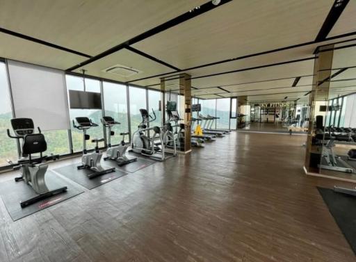 Spacious gym area with modern equipment and floor-to-ceiling windows